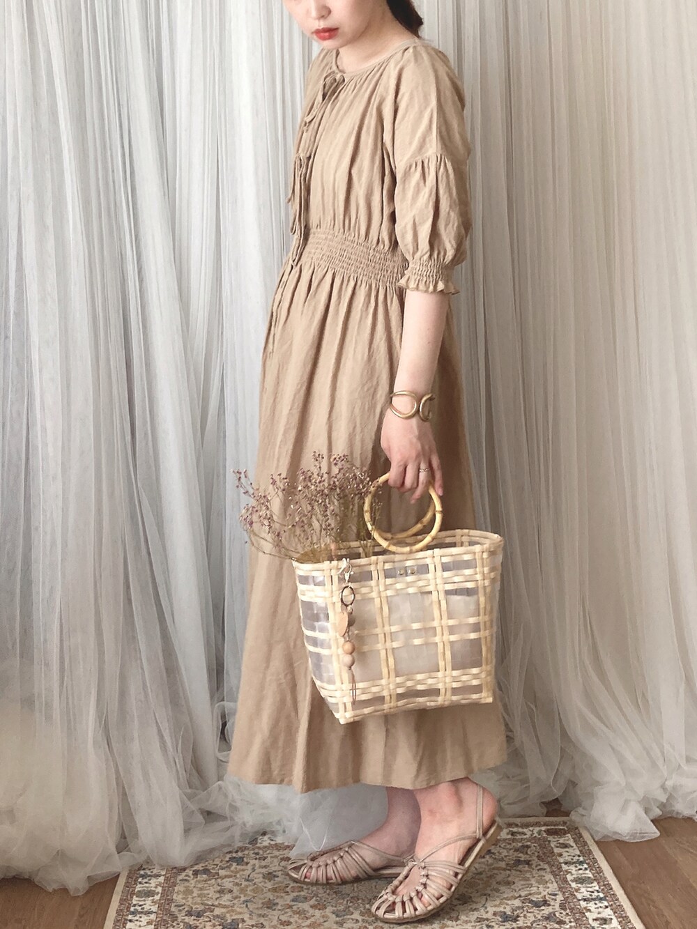 ベージュ系のハンドバッグ、ベージュ系のサンダル、ベージュ系のワンピースを着用したレディースの秋コーディネートの4枚目の写真