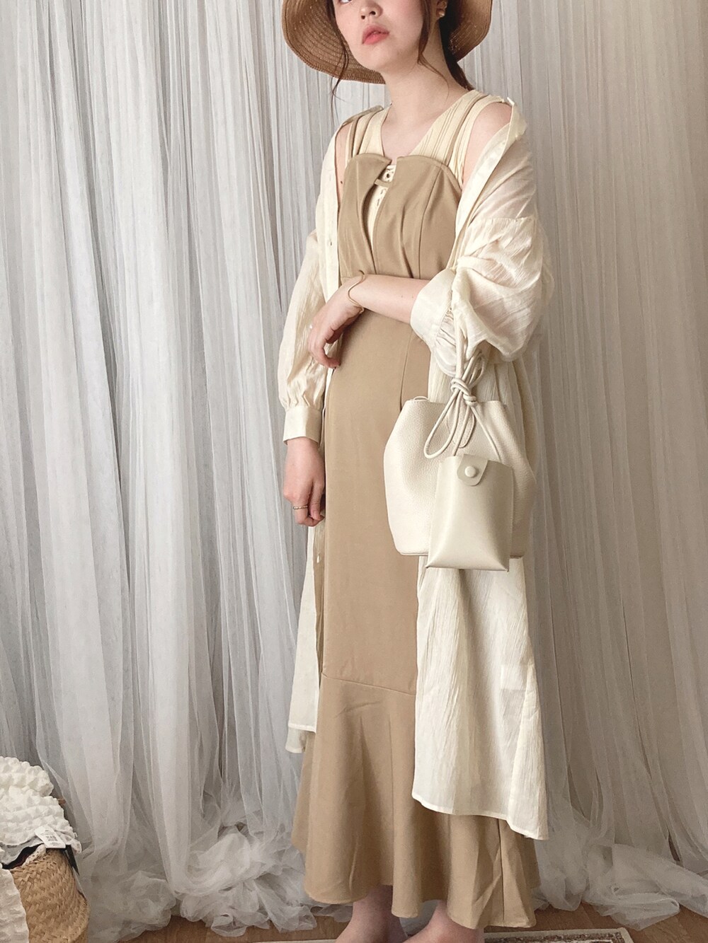 ベージュ系のワンピース、ホワイト系のニット/セーター、ホワイト系のワンピースを着用したレディースの夏コーディネートの4枚目の写真