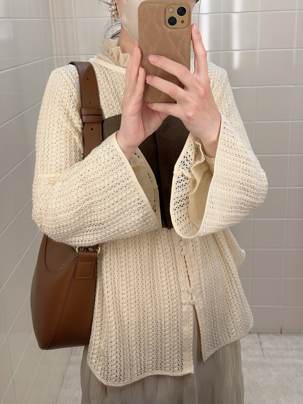 ブラウン系のベスト、ベージュ系のシャツ/ブラウス、ホワイト系のワンピースを着用したレディースの春コーディネートの3枚目の写真