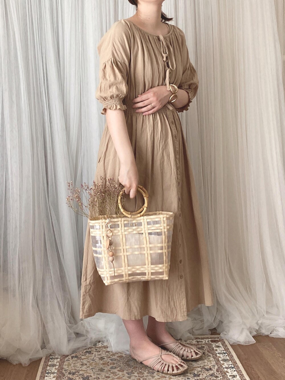 ベージュ系のハンドバッグ、ベージュ系のサンダル、ベージュ系のワンピースを着用したレディースの秋コーディネートの3枚目の写真