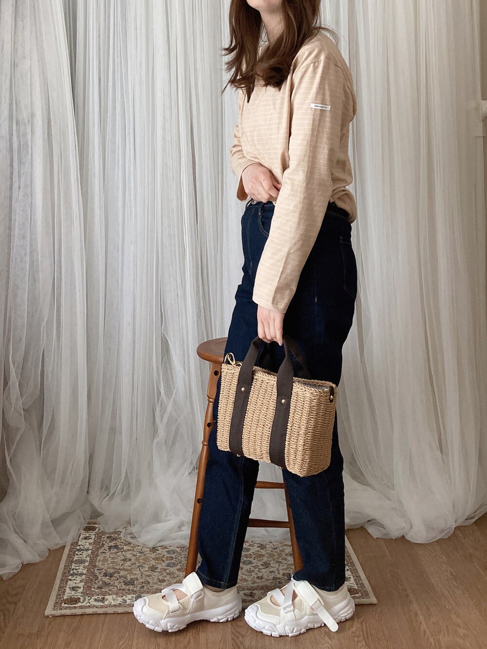 ベージュ系のTシャツ/カットソー、ブラック系のデニムパンツ、ブラウン系のかごバッグを着用したレディースの夏コーディネートの2枚目の写真