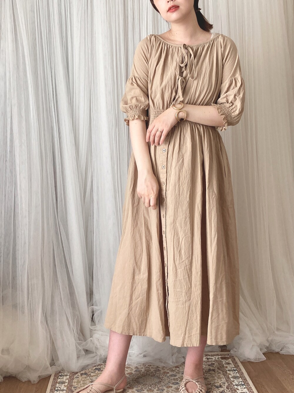 ベージュ系のハンドバッグ、ベージュ系のサンダル、ベージュ系のワンピースを着用したレディースの秋コーディネートの5枚目の写真