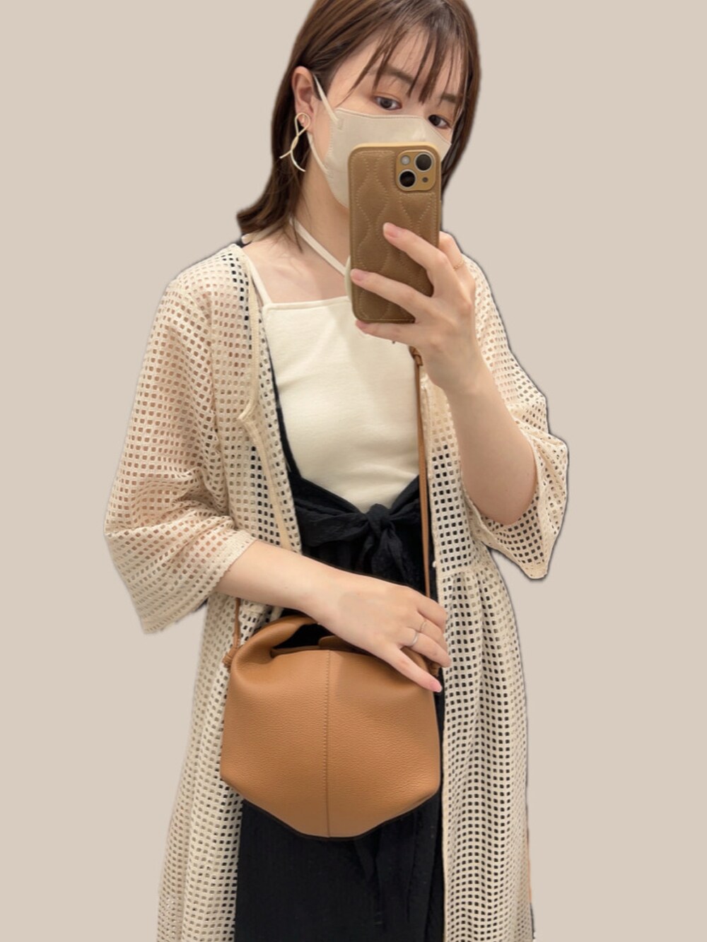 ブラウン系のショルダーバッグ、ベージュ系のカーディガン/ボレロ、ブラック系のワンピースを着用したレディースの夏コーディネートの2枚目の写真