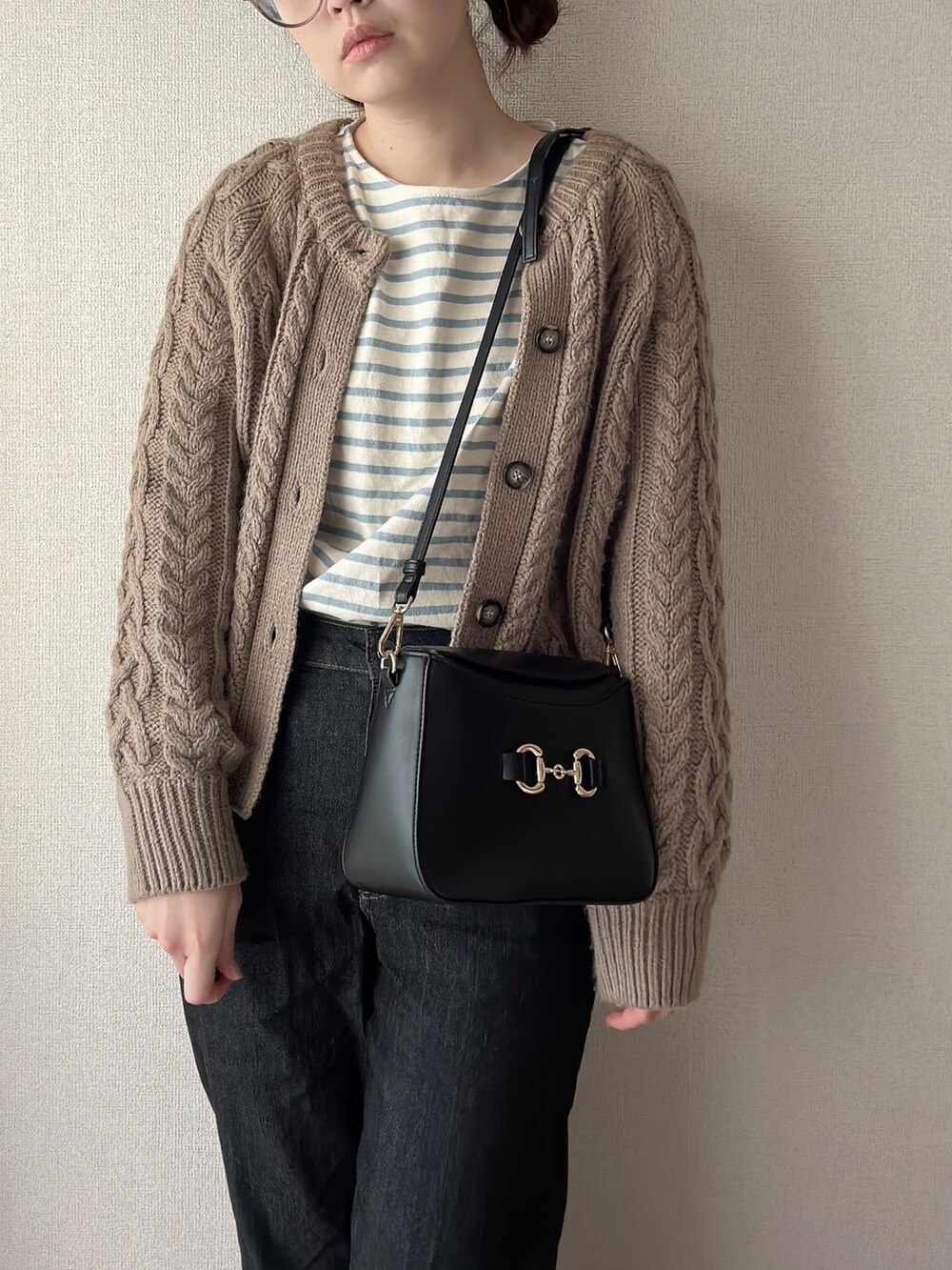 ブラック系のショルダーバッグ、ブルー系のTシャツ/カットソー、ベージュ系のメガネを着用したレディースの春コーディネートの3枚目の写真