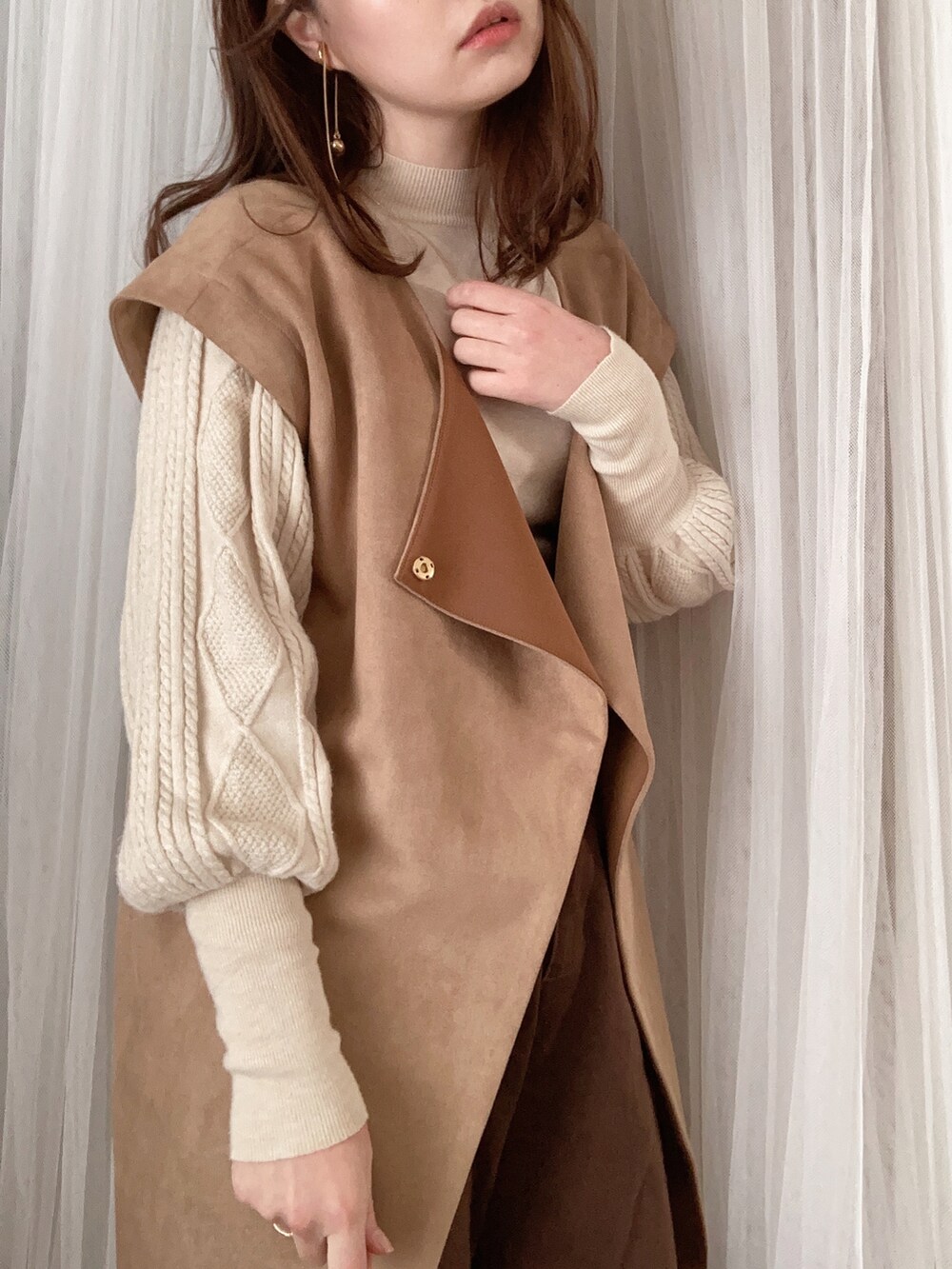 ブラウン系のショルダーバッグ、ベージュ系のその他アウター、ベージュ系のニット/セーターを着用したレディースの冬コーディネートの5枚目の写真