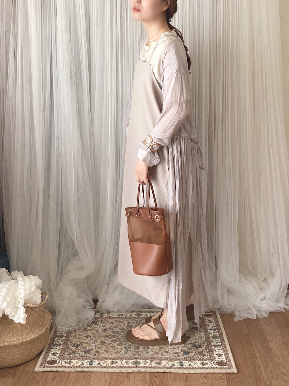 ブラウン系のトートバッグ、ブラウン系のサンダル、ホワイト系のTシャツ/カットソーを着用したレディースの夏コーディネートの4枚目の写真