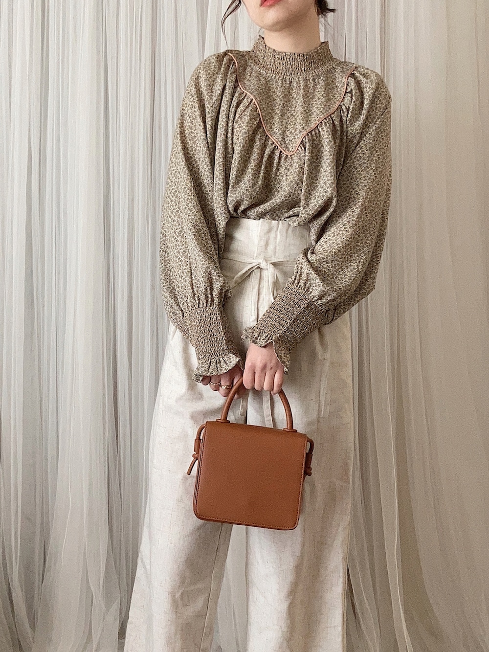 ベージュ系のシャツ/ブラウス、ブラウン系のショルダーバッグ、ブラウン系のローファーを着用したレディースの冬コーディネートの2枚目の写真