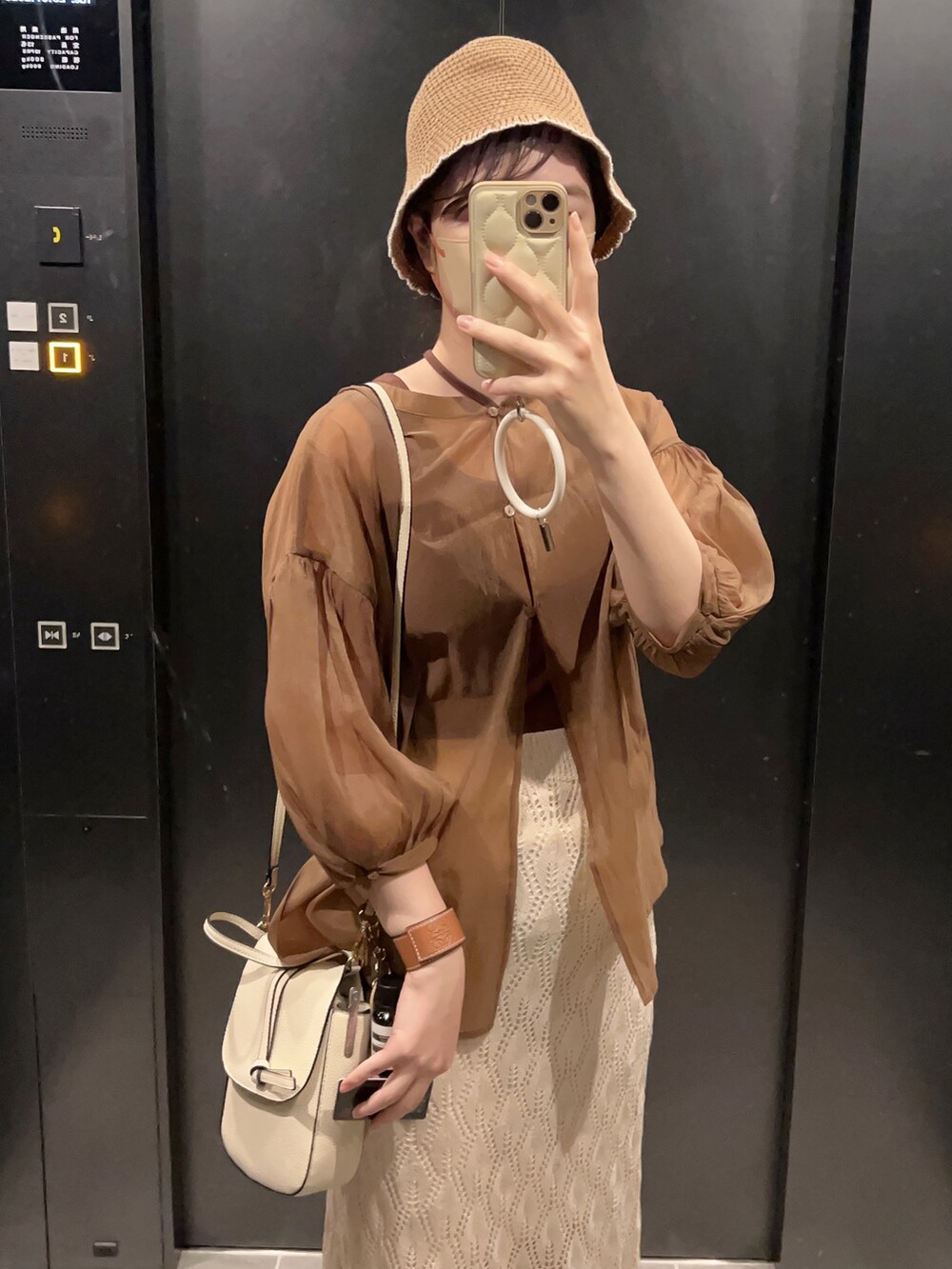 ブラウン系のシャツ/ブラウス、ホワイト系のショルダーバッグ、ホワイト系のスカートを着用したレディースの秋コーディネートの3枚目の写真