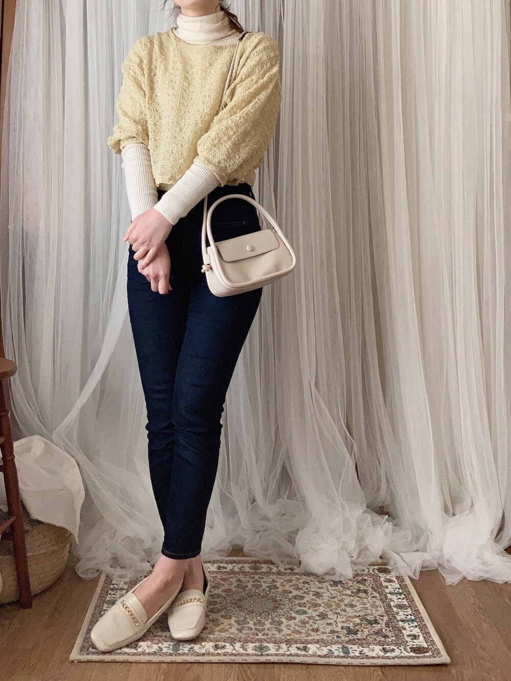 ホワイト系のパンプス、ホワイト系のショルダーバッグ、イエロー系のトップスを着用したレディースの春コーディネートの3枚目の写真