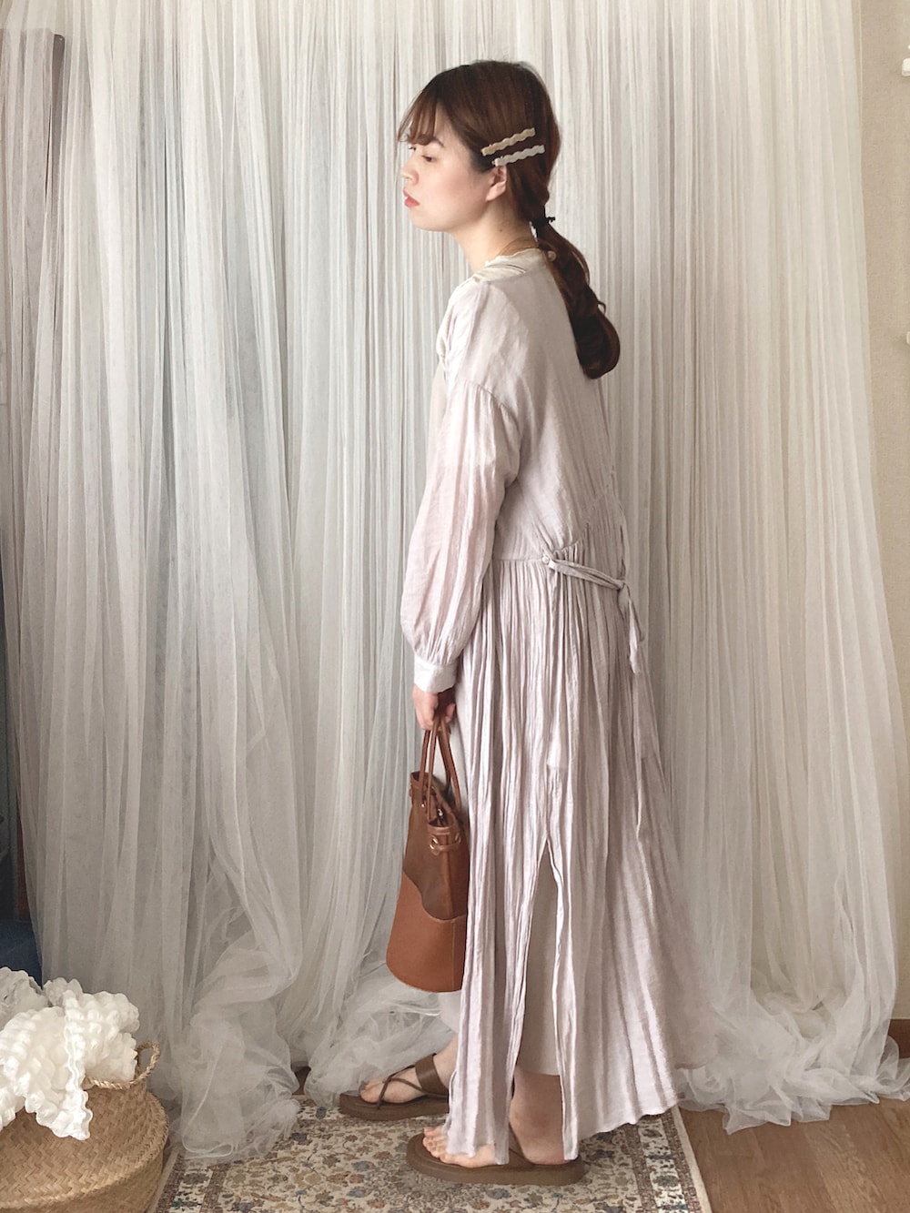 ブラウン系のトートバッグ、ブラウン系のサンダル、ホワイト系のTシャツ/カットソーを着用したレディースの夏コーディネートの5枚目の写真