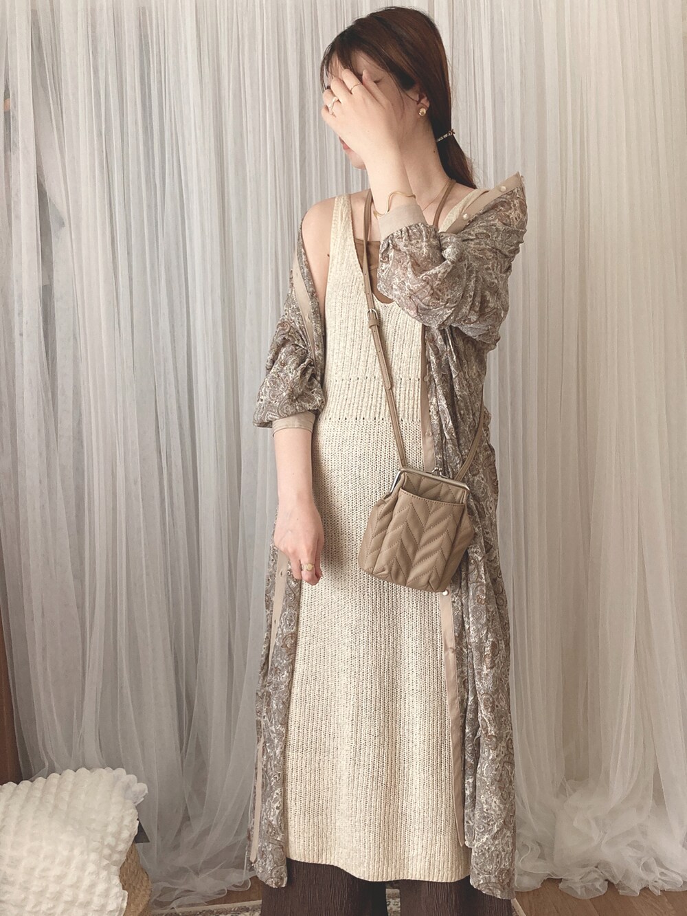 ベージュ系のワンピース、ベージュ系のショルダーバッグ、ブラウン系のキャミソールを着用したレディースの夏コーディネートの3枚目の写真