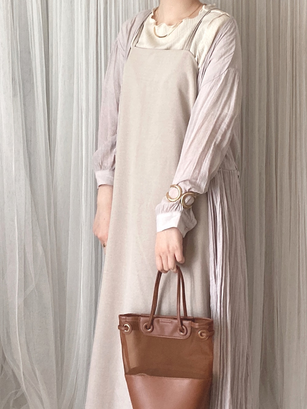 ブラウン系のトートバッグ、ブラウン系のサンダル、ホワイト系のTシャツ/カットソーを着用したレディースの夏コーディネートの3枚目の写真