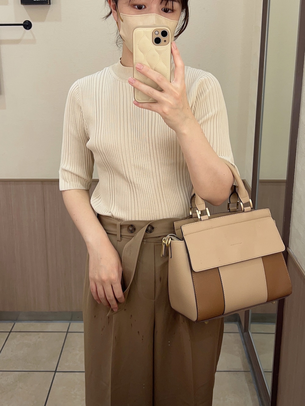 ベージュ系のトートバッグ、ベージュ系のTシャツ/カットソー、ベージュ系のパンツを着用したレディースの秋コーディネートの2枚目の写真