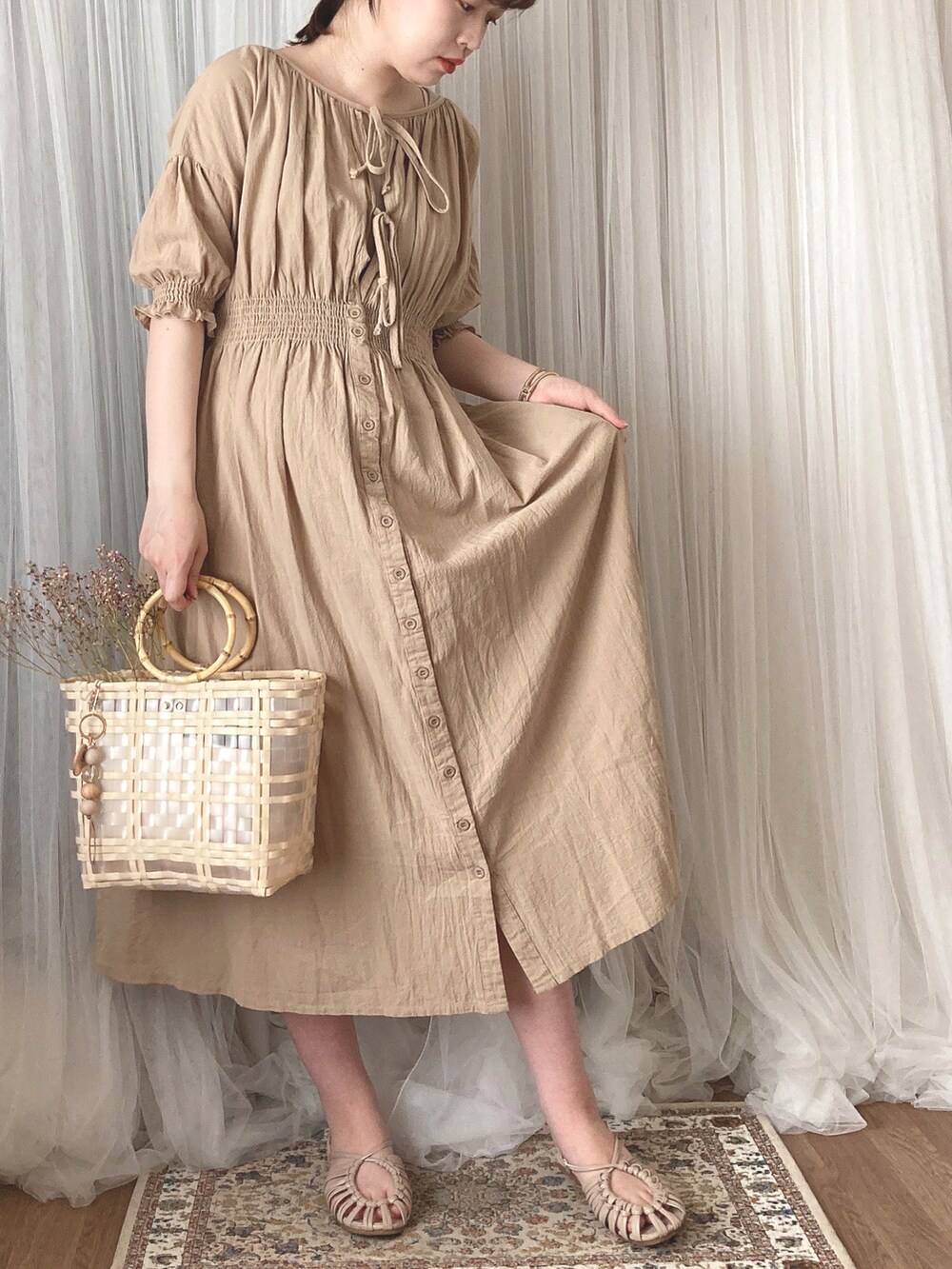 ベージュ系のハンドバッグ、ベージュ系のサンダル、ベージュ系のワンピースを着用したレディースの秋コーディネートの2枚目の写真