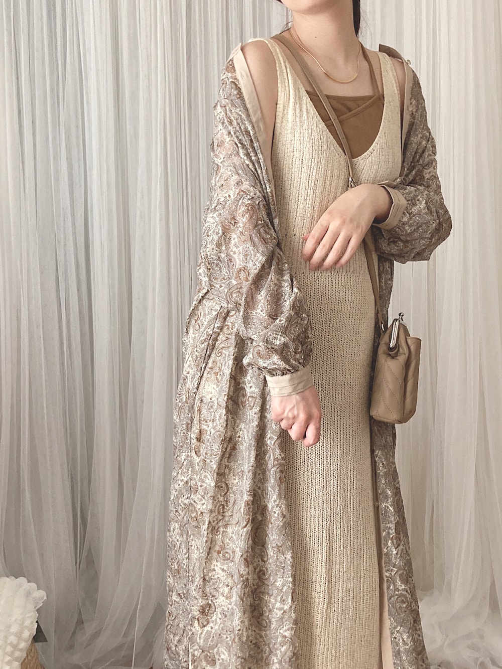 ベージュ系のワンピース、ベージュ系のショルダーバッグ、ブラウン系のキャミソールを着用したレディースの夏コーディネートの2枚目の写真