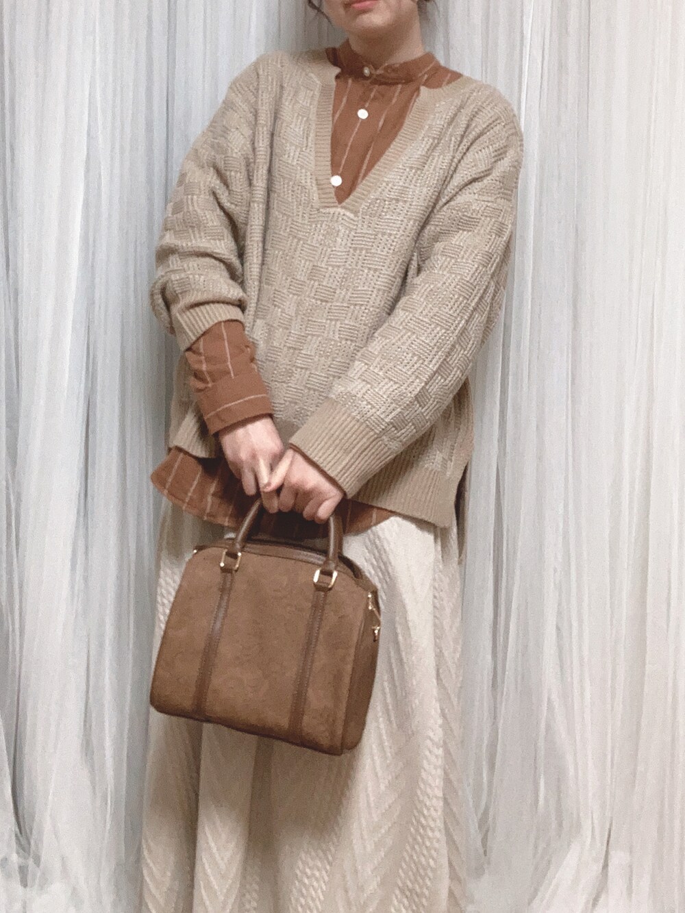 ブラウン系のボストンバッグ、ホワイト系のスカート、ブラウン系のノーカラージャケットを着用したレディースの冬コーディネートの4枚目の写真