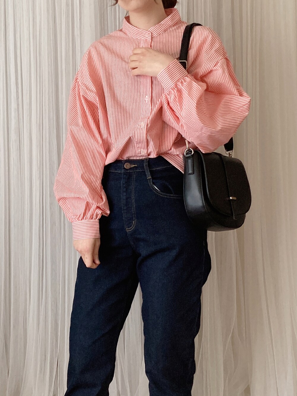 ブラック系のデニムパンツ、ブラック系のショルダーバッグ、オレンジ系のシャツ/ブラウスを着用したレディースの夏コーディネートの2枚目の写真