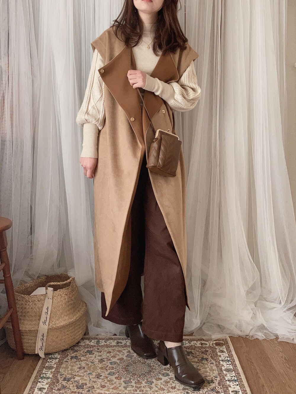 ブラウン系のショルダーバッグ、ベージュ系のその他アウター、ベージュ系のニット/セーターを着用したレディースの冬コーディネートの2枚目の写真