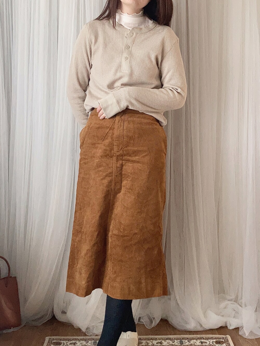 ホワイト系のバッグ、ブラウン系のノーカラージャケット、ベージュ系のTシャツ/カットソーを着用したレディースの冬コーディネートの3枚目の写真