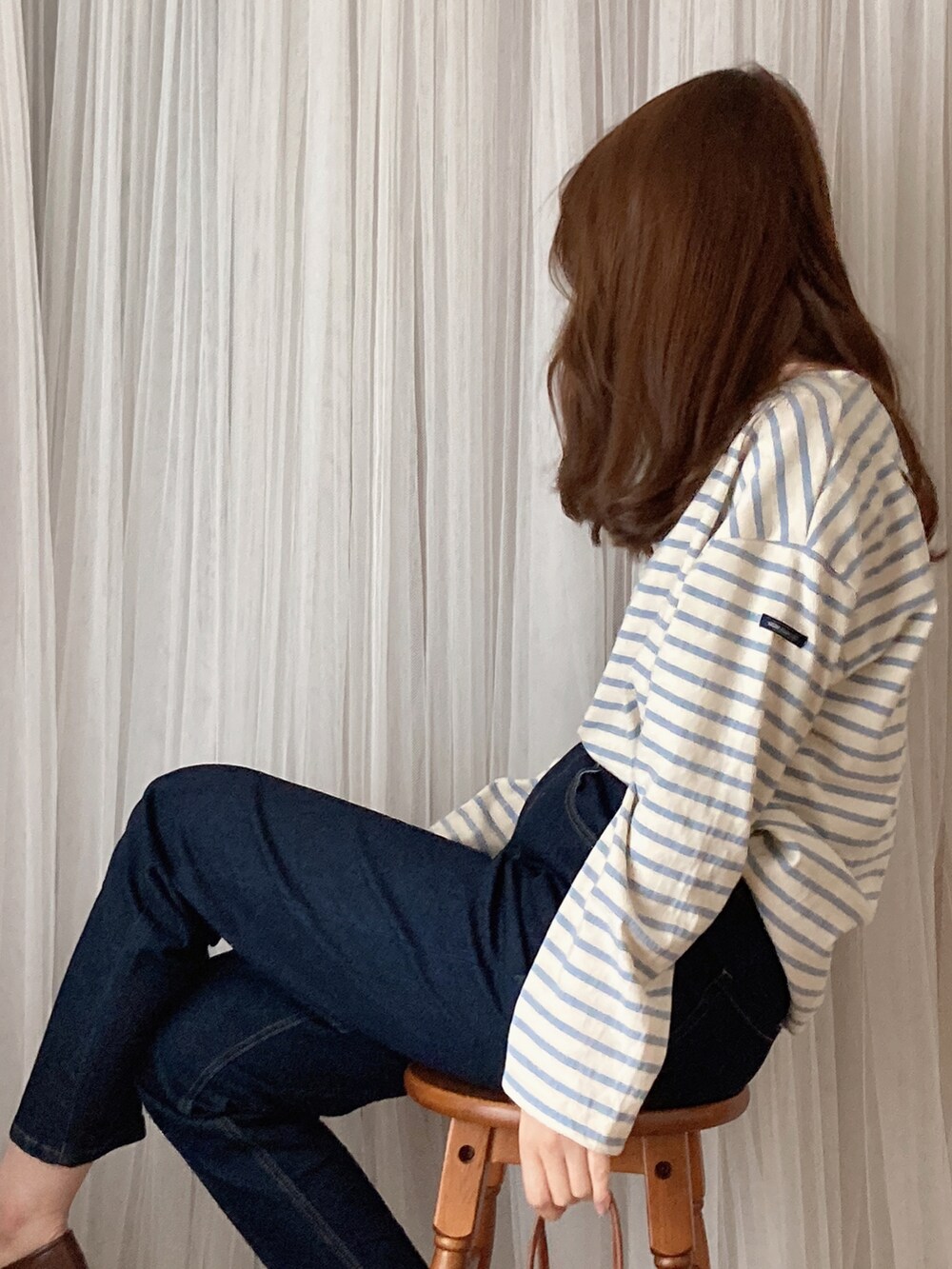 ブラウン系のトートバッグ、ブラウン系のパンプス、ブラック系のデニムパンツを着用したレディースの夏コーディネートの3枚目の写真