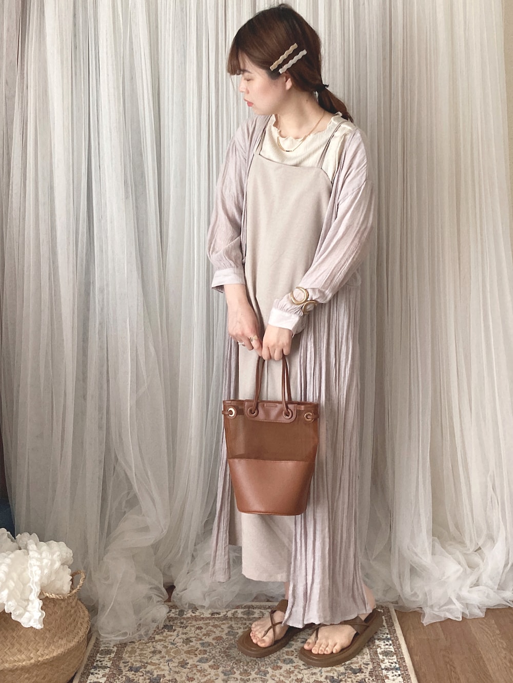 ブラウン系のトートバッグ、ブラウン系のサンダル、ホワイト系のTシャツ/カットソーを着用したレディースの夏コーディネートの2枚目の写真