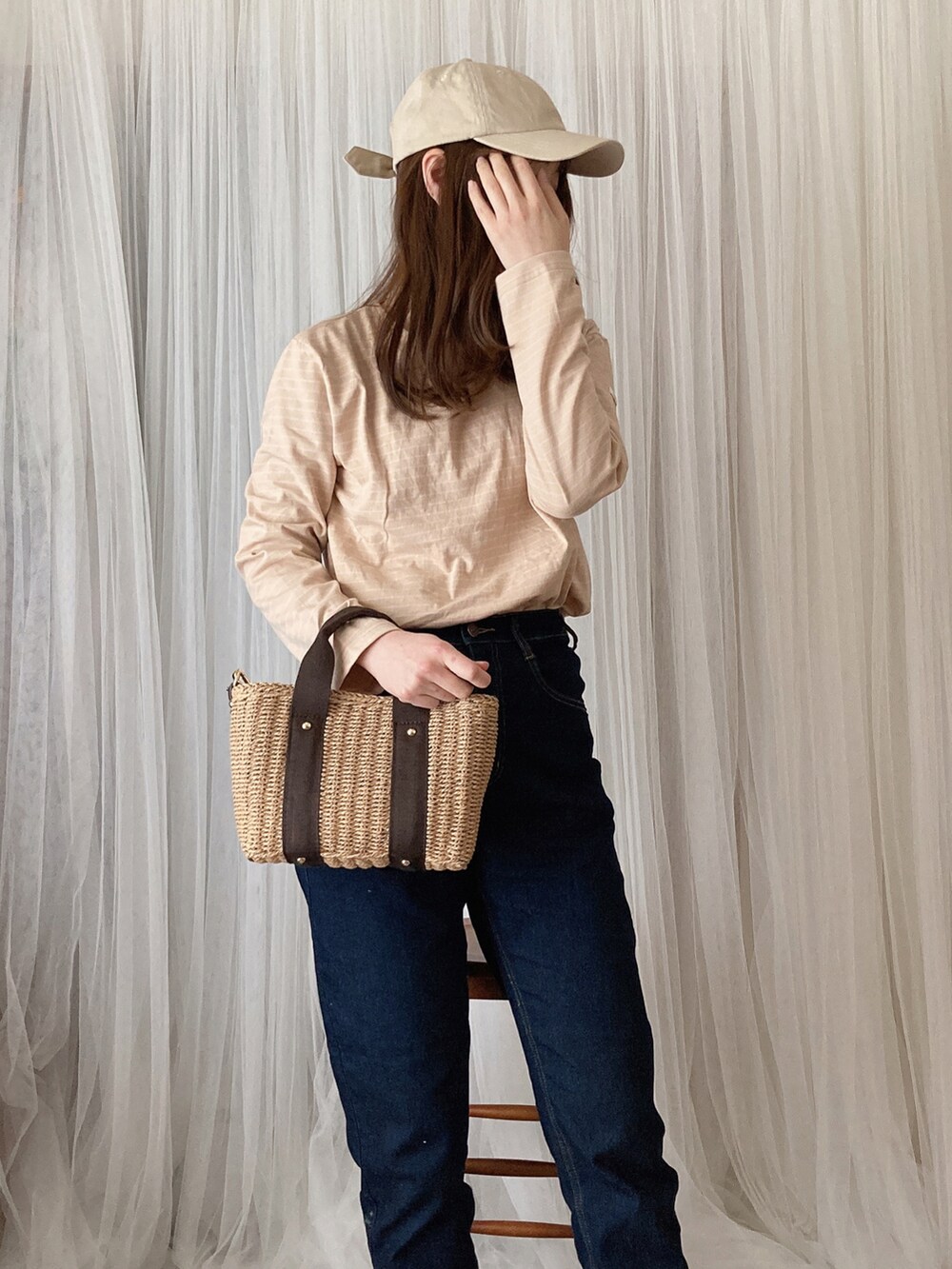 ベージュ系のTシャツ/カットソー、ブラック系のデニムパンツ、ブラウン系のかごバッグを着用したレディースの夏コーディネートの3枚目の写真