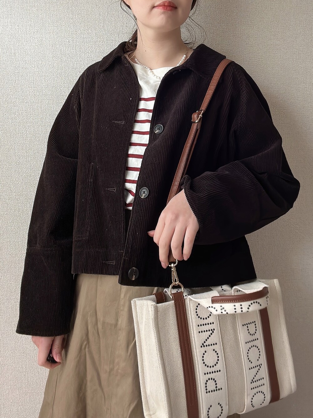 ブラウン系のブルゾン、ベージュ系のトートバッグ、その他のTシャツ/カットソーを着用したレディースの春コーディネートの2枚目の写真