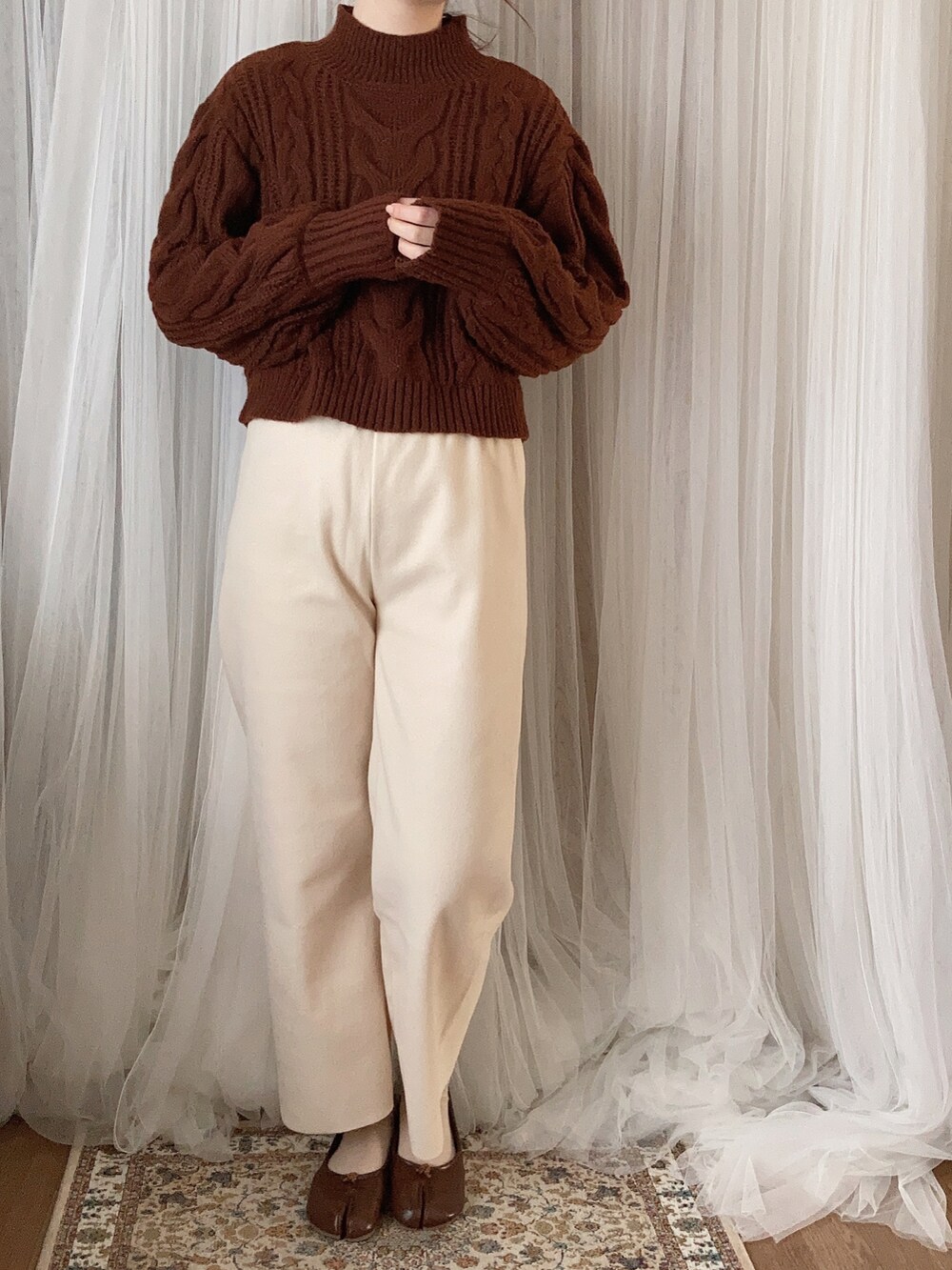 ホワイト系のジャケット/アウター、ブラウン系のニット/セーター、ホワイト系のその他パンツを着用したレディースの冬コーディネートの3枚目の写真