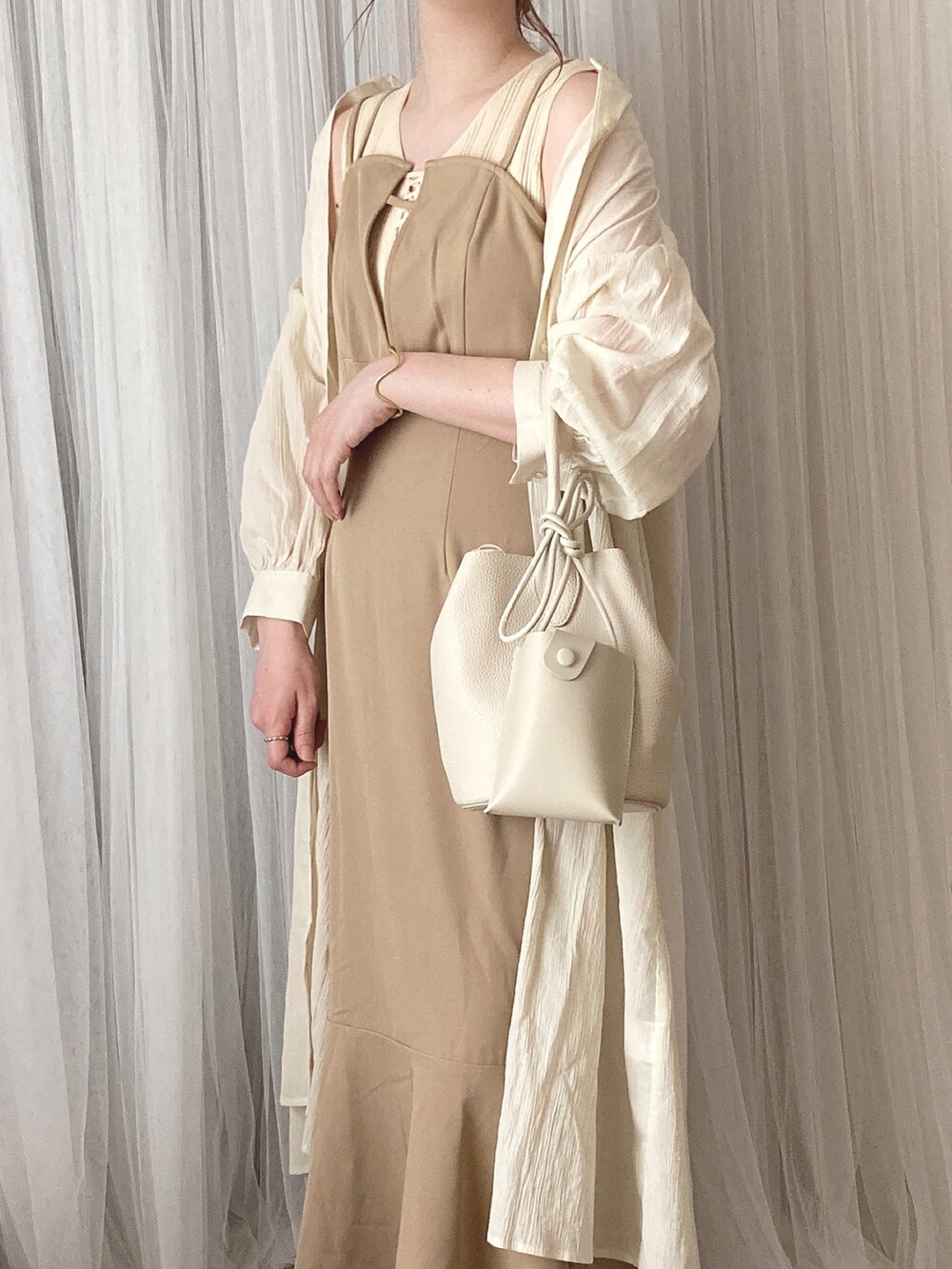 ベージュ系のワンピース、ホワイト系のニット/セーター、ホワイト系のワンピースを着用したレディースの夏コーディネートの2枚目の写真