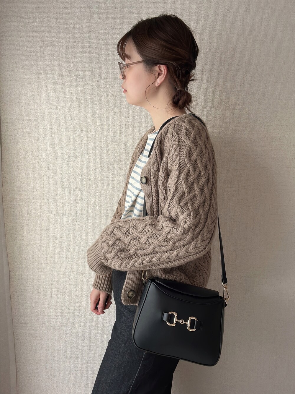 ブラック系のショルダーバッグ、ブルー系のTシャツ/カットソー、ベージュ系のメガネを着用したレディースの春コーディネートの2枚目の写真