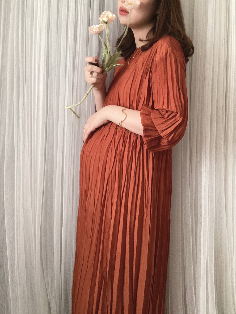 ベージュ系のバッグ、ベージュ系のサンダル、オレンジ系のワンピースを着用したレディースの秋コーディネートの4枚目の写真