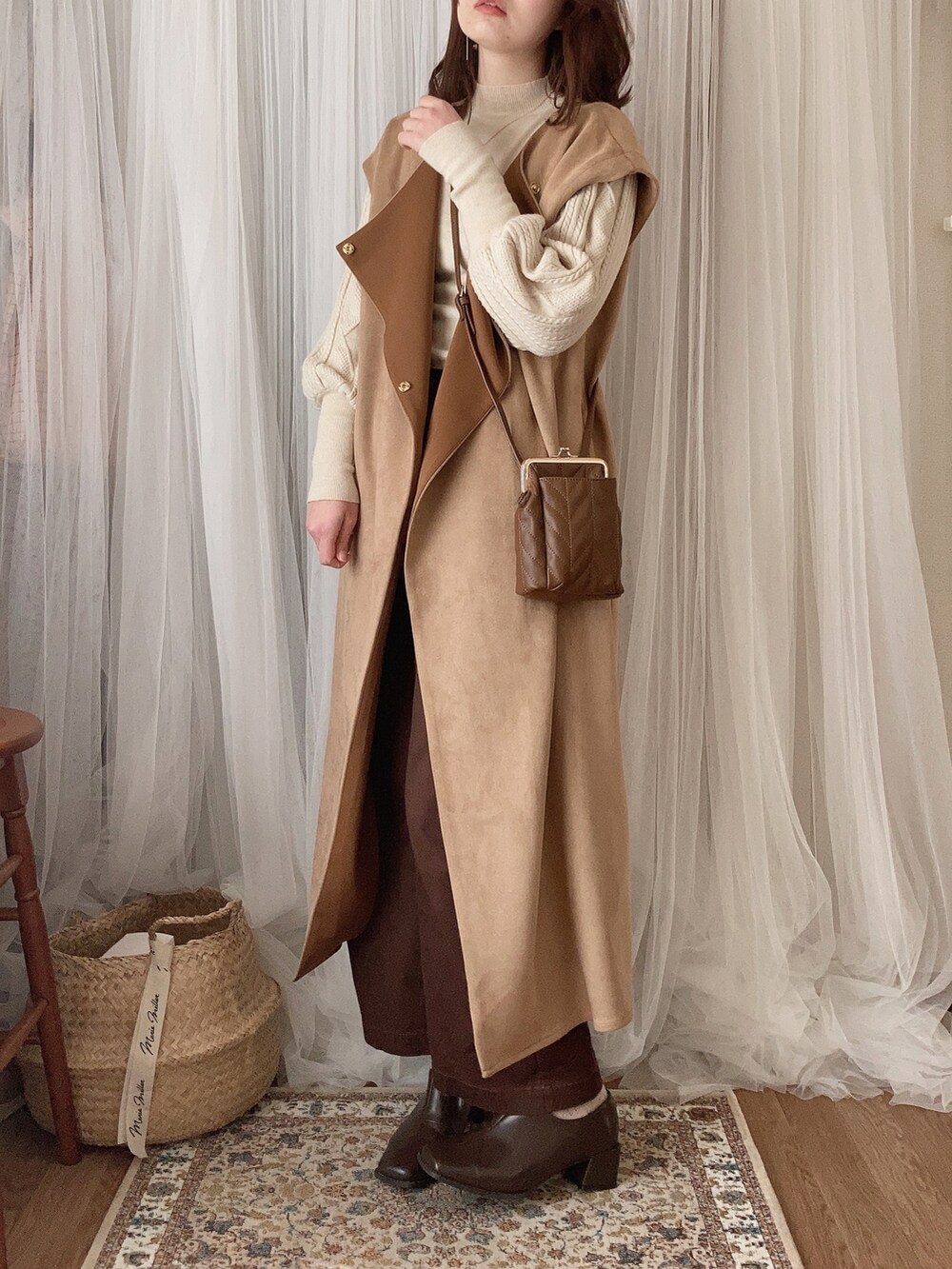 ブラウン系のショルダーバッグ、ベージュ系のその他アウター、ベージュ系のニット/セーターを着用したレディースの冬コーディネートの3枚目の写真