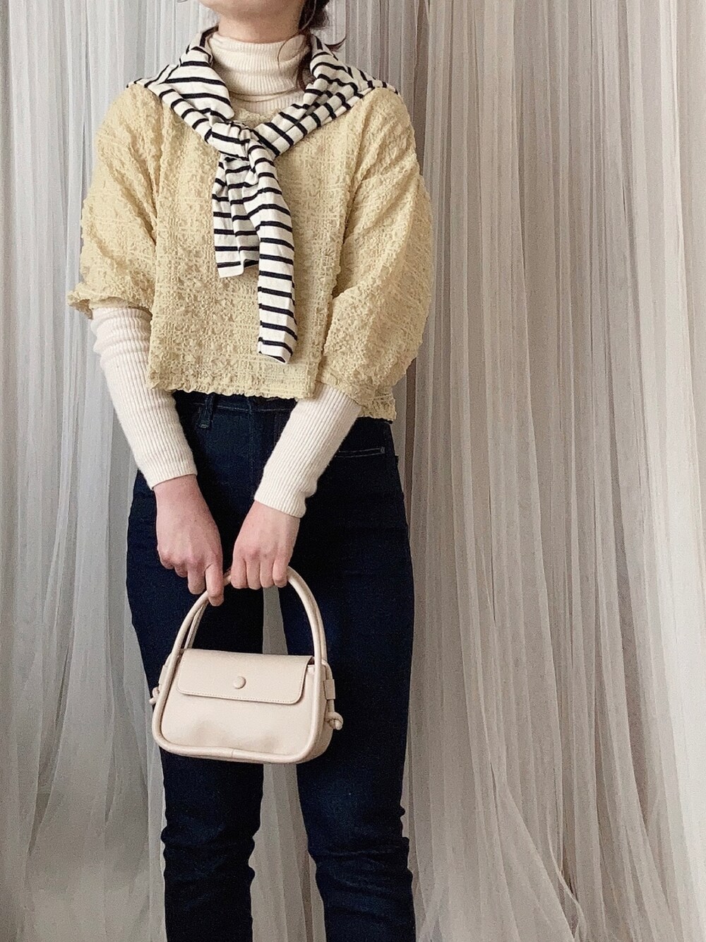 ホワイト系のパンプス、ホワイト系のショルダーバッグ、イエロー系のトップスを着用したレディースの春コーディネートの2枚目の写真