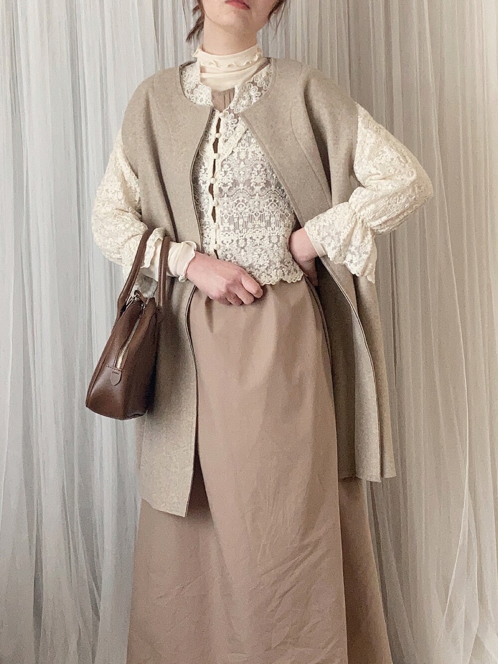 ブラウン系のボストンバッグ、ブラウン系のパンプス、ベージュ系のその他アウターを着用したレディースの春コーディネートの3枚目の写真