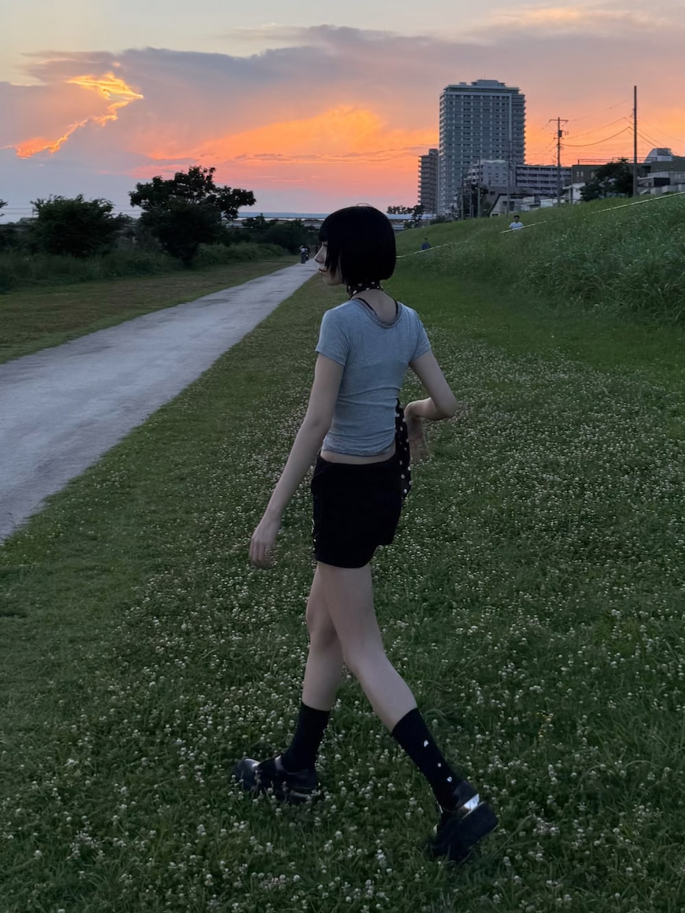 グレー系のTシャツ/カットソー、ブラック系のスカート、ブラック系のソックス/靴下を着用したレディースの夏コーディネートの2枚目の写真