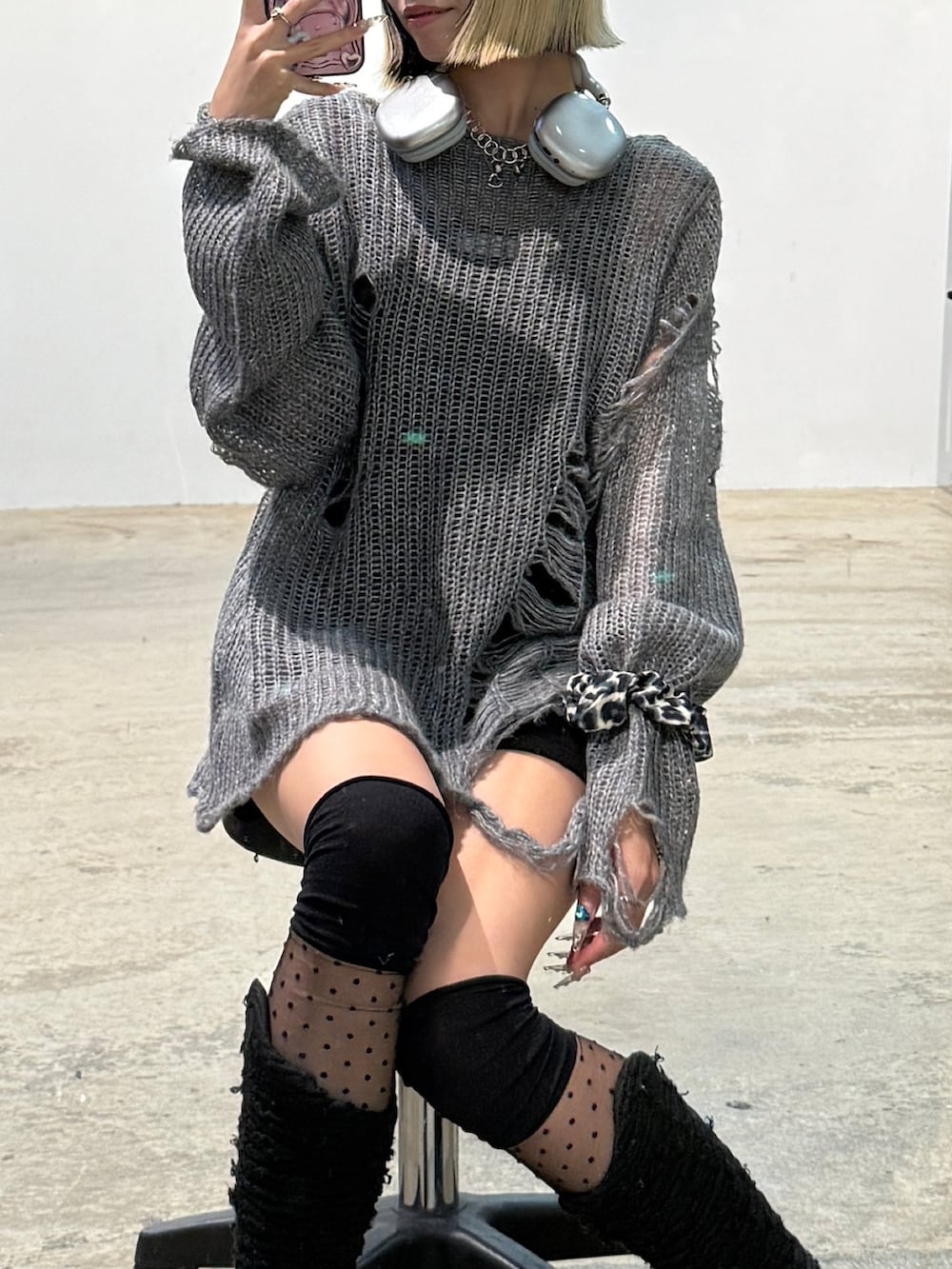 グレー系のニット/セーター、ブラック系のその他パンツ、ブラック系のブーツを着用したレディースの秋コーディネートの2枚目の写真