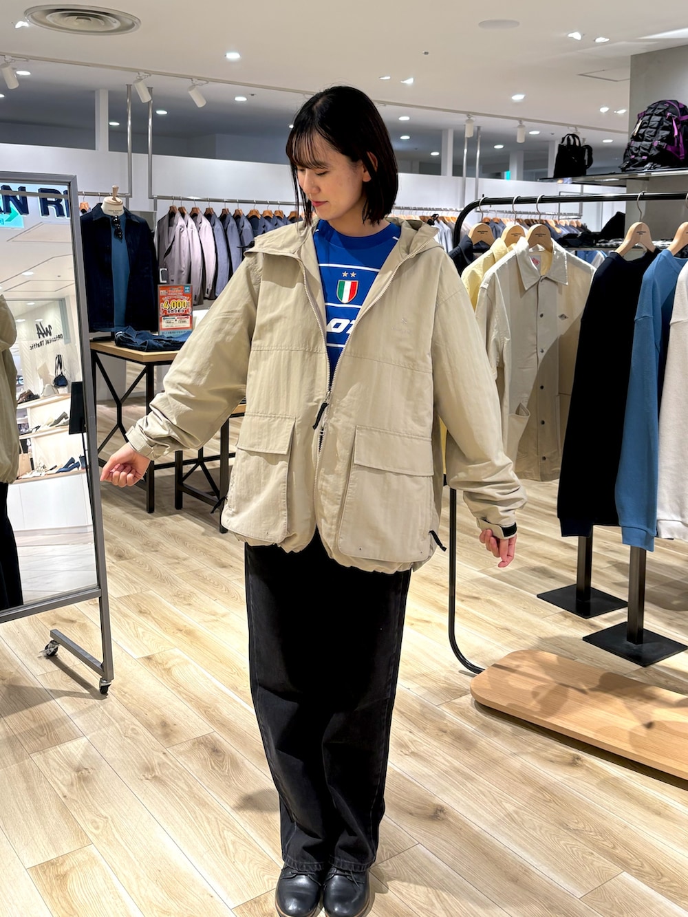 ブラック系のデニムパンツ、ブルー系のTシャツ/カットソー、ブラック系のナイロンジャケットを着用したレディースの春コーディネートの2枚目の写真