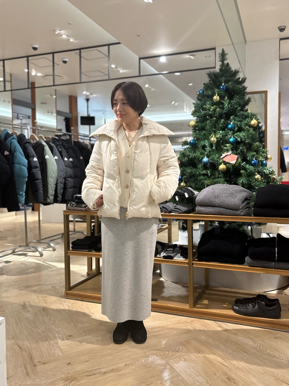 ホワイト系のダウンジャケット/コート、ホワイト系のカーディガン/ボレロ、グレー系のスカートを着用したレディースの秋コーディネートの2枚目の写真