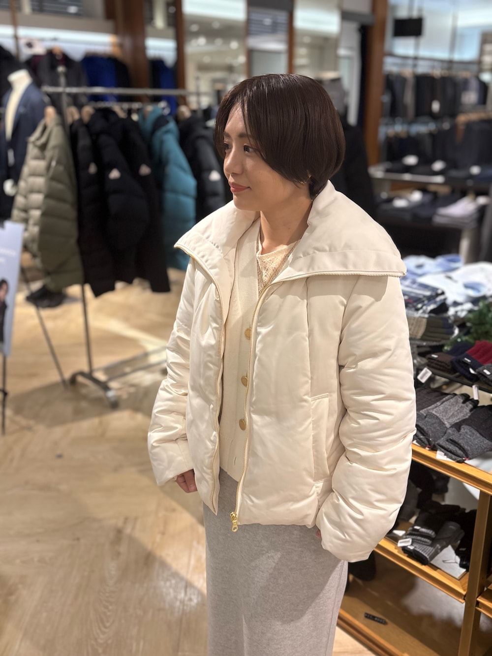 ホワイト系のダウンジャケット/コート、ホワイト系のカーディガン/ボレロ、グレー系のスカートを着用したレディースの秋コーディネートの3枚目の写真