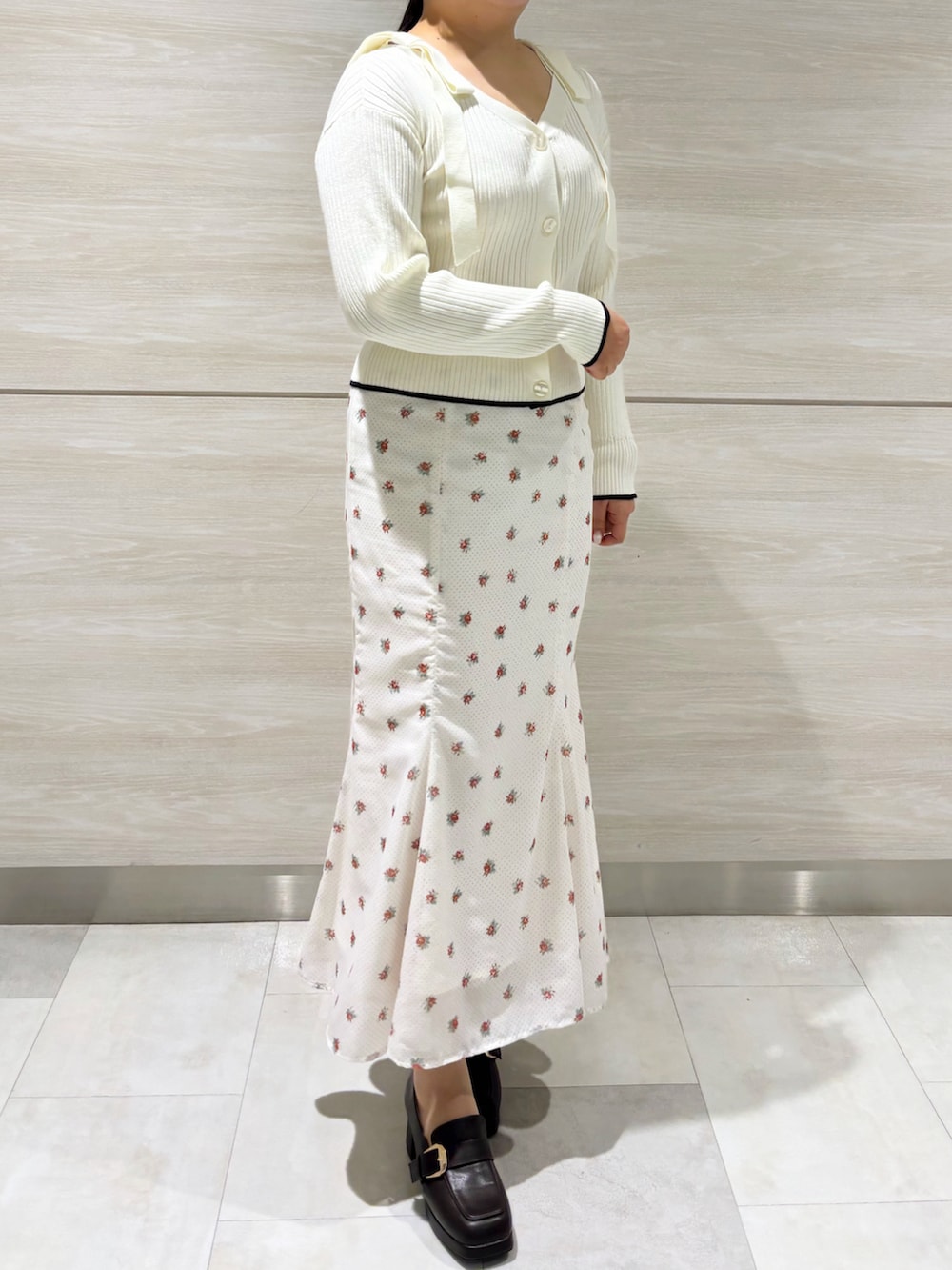 ホワイト系のニット/セーター、ホワイト系のスカートを着用したレディースの春コーディネートの2枚目の写真