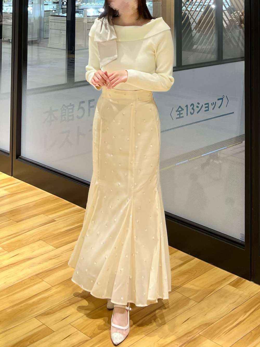 イエロー系のスカート、ホワイト系のニット/セーターを着用したレディースの春コーディネートの3枚目の写真