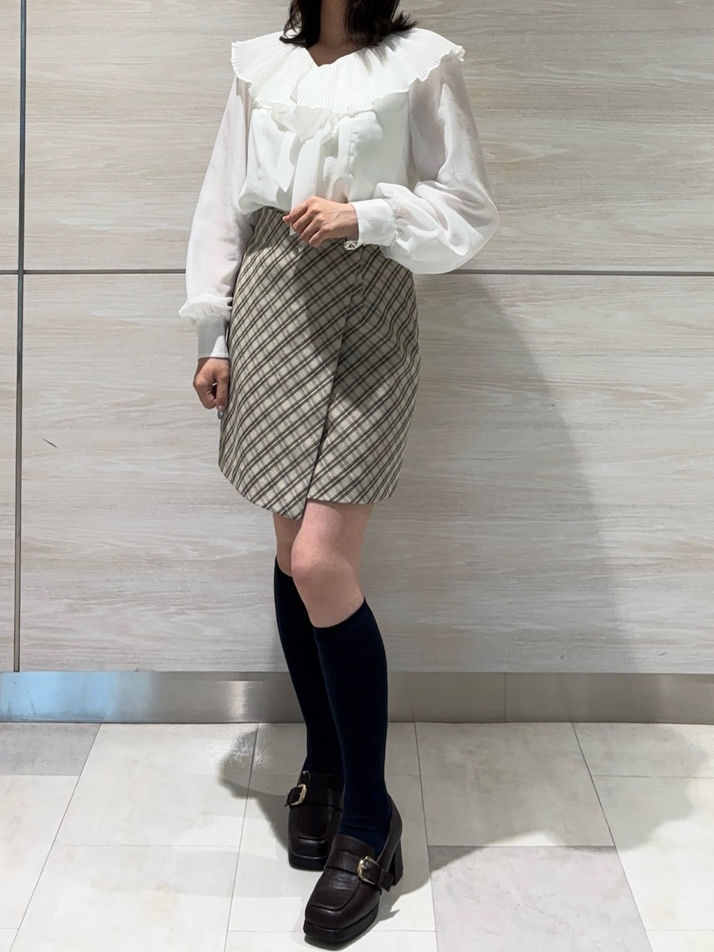 ホワイト系のシャツ/ブラウス、ベージュ系のスカートを着用したレディースの春コーディネートの2枚目の写真