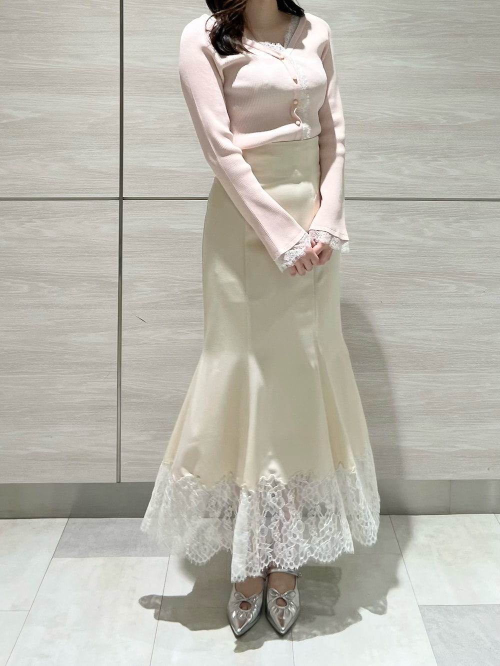 ピンク系のニット/セーター、ホワイト系のスカートを着用したレディースの春コーディネートの3枚目の写真