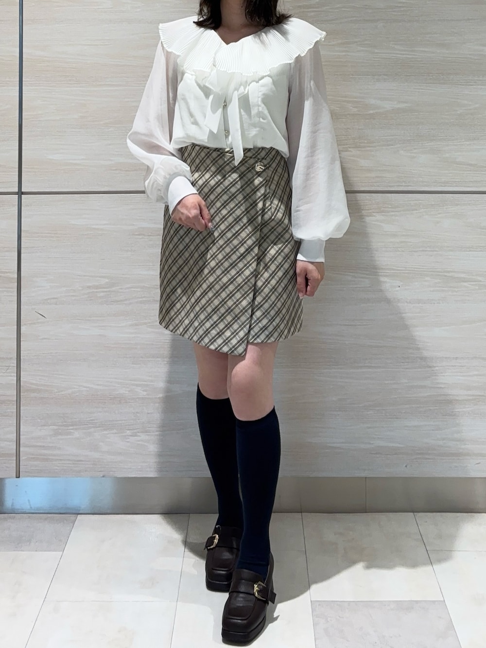 ホワイト系のシャツ/ブラウス、ベージュ系のスカートを着用したレディースの春コーディネートの3枚目の写真