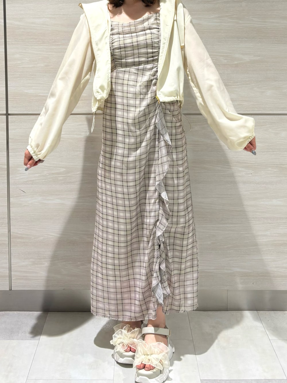 グリーン系のワンピース、ホワイト系のブルゾンを着用したレディースの春コーディネートの2枚目の写真