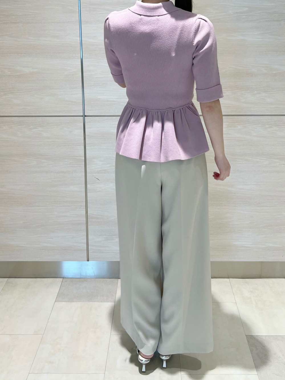 ピンク系のニット/セーター、ホワイト系のパンツを着用したレディースの春コーディネートの4枚目の写真