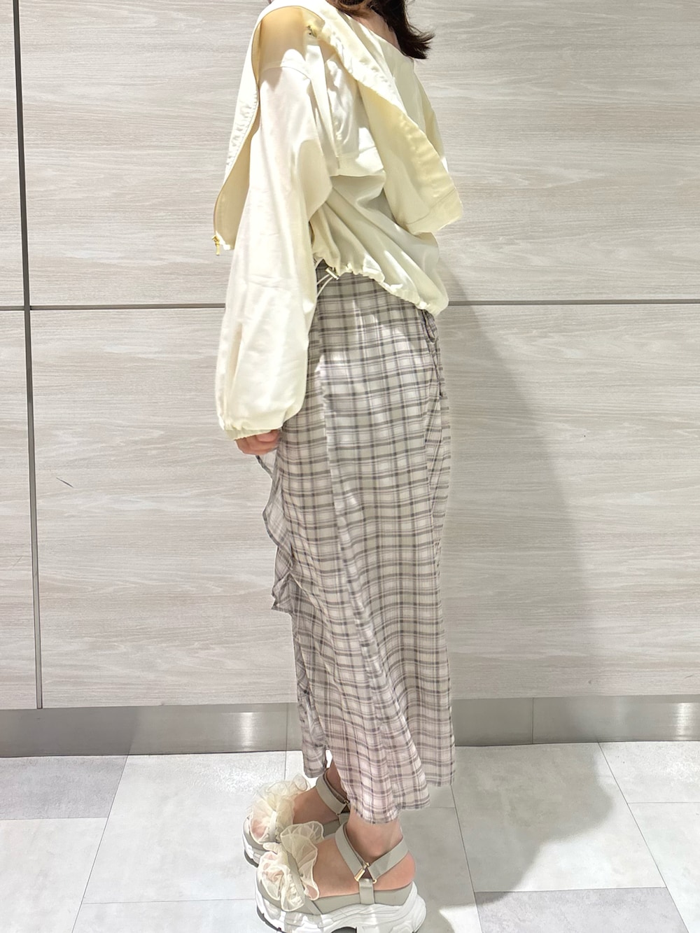 グリーン系のワンピース、ホワイト系のブルゾンを着用したレディースの春コーディネートの3枚目の写真