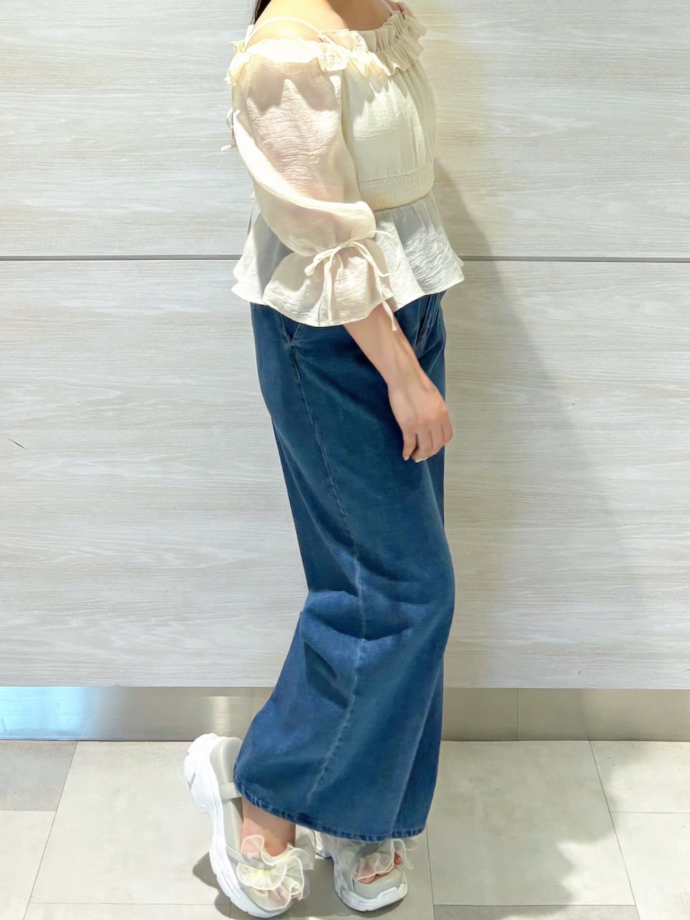 ベージュ系のシャツ/ブラウス、ブルー系のデニムパンツを着用したレディースの春コーディネートの3枚目の写真