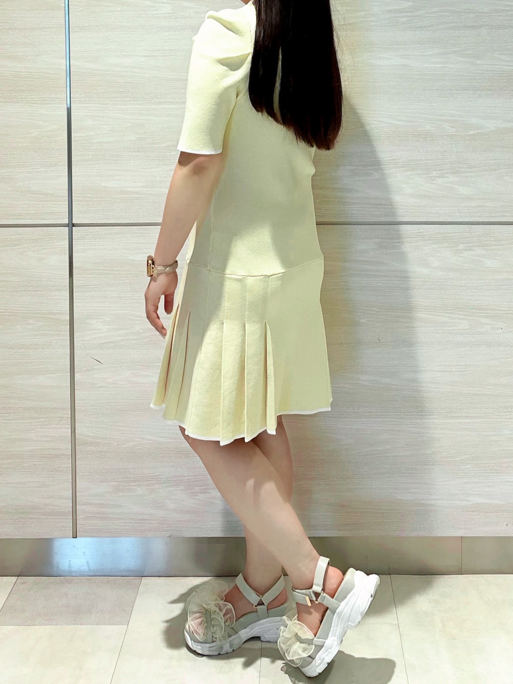 イエロー系のワンピースを着用したレディースの春コーディネートの3枚目の写真