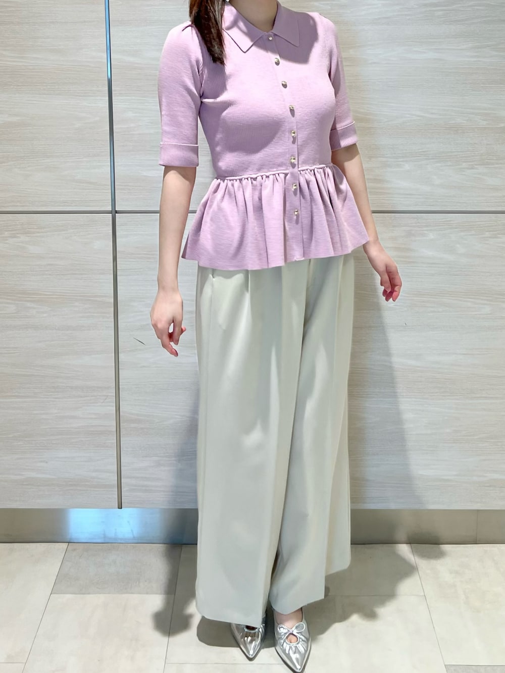 ピンク系のニット/セーター、ホワイト系のパンツを着用したレディースの春コーディネートの2枚目の写真